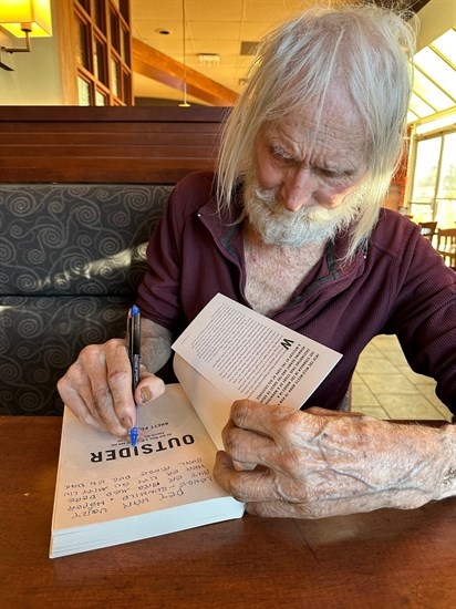 Dag Aabye signing a copy of the book written about him.