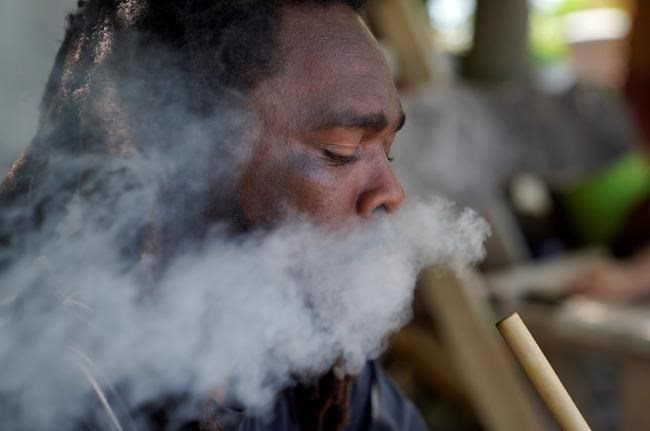 Ras Richie, a member of the Ras Freeman Foundation for the Unification of Rastafari, smokes cannabis from a chalice pipe on Saturday, May 13, 2023, in Liberta, Antigua.
