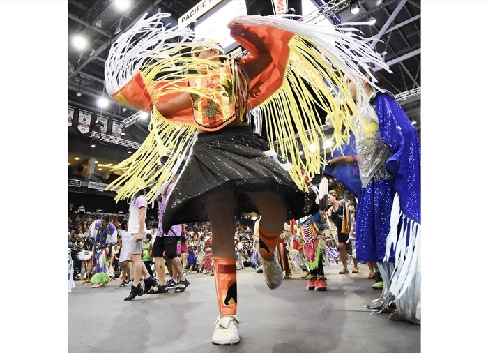 A young dancer spins on the floor prior to the start of competition in the Between the Lakes pow wow.