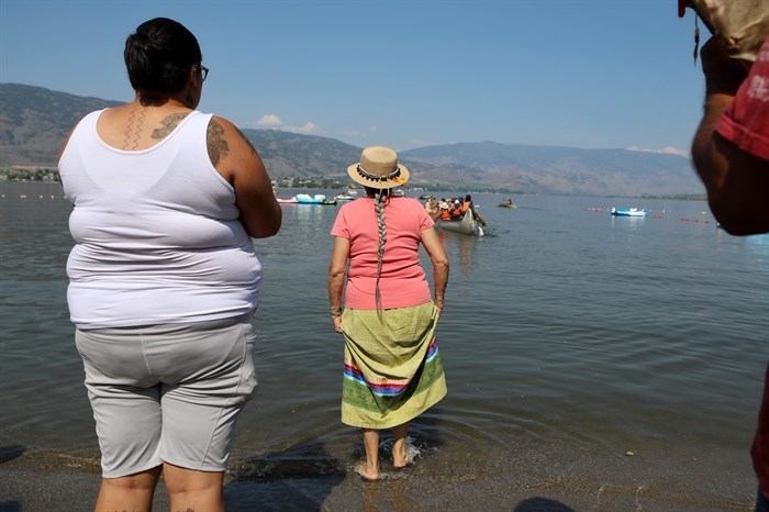 tsouli Joanne Edward, centre, watches as canoes leave for the cross-border journey to Oroville, Washington, from nk’mip (Osoyoos Lake) in sw?iw?s (Osoyoos) in syilx homelands on July 4, 2023.