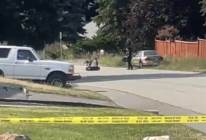 An RCMP officer with the explosive disposal team is scene carrying the pipe bomb from the Sifton Avenue scene in a container on July 5, 2023.