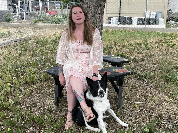 Kamloops resident and recovering drug addict Cindy Dixon sits in her daughter's back yard with her daughter's dog, Chance.