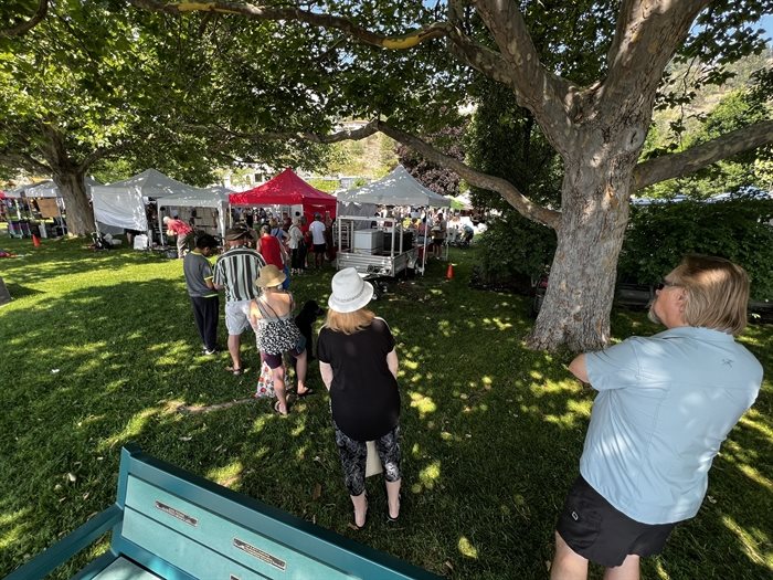 A long line-up of customers in front of A Sweet Romance bakery stall at the Peachand Crafters and Farmers market at Heritage Park, Peachland. 