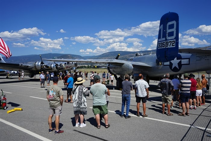 Members of the public lineup to view the Second World War bombers on display at the Penticton airport, Thursday, July 20, 2023.