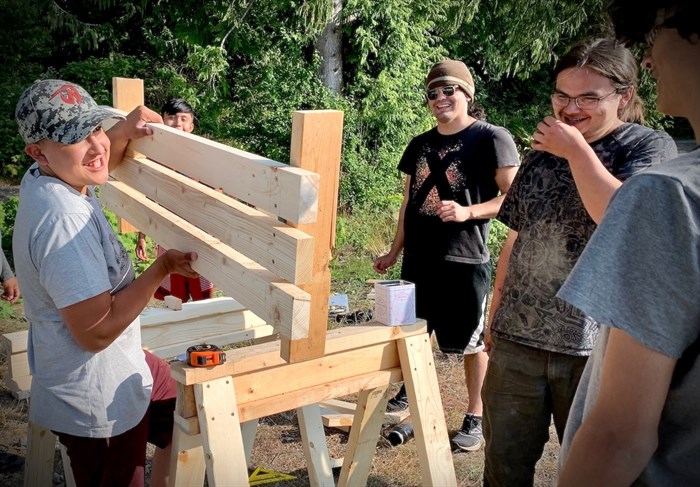 Members of the Youth Warrior program have a laugh during a carpentry project.