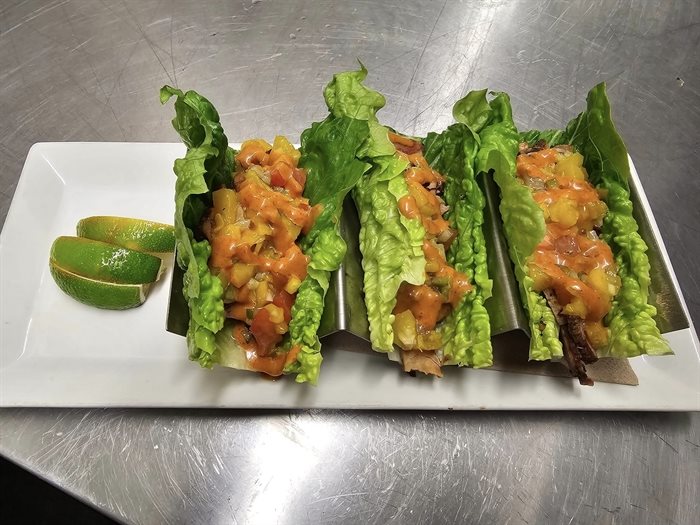 Gluten free smoked pork tacos on lettuce wraps with fresh peach pico de gallo and a chipotle aioli on top at Beachcider Bar in Penticton. 