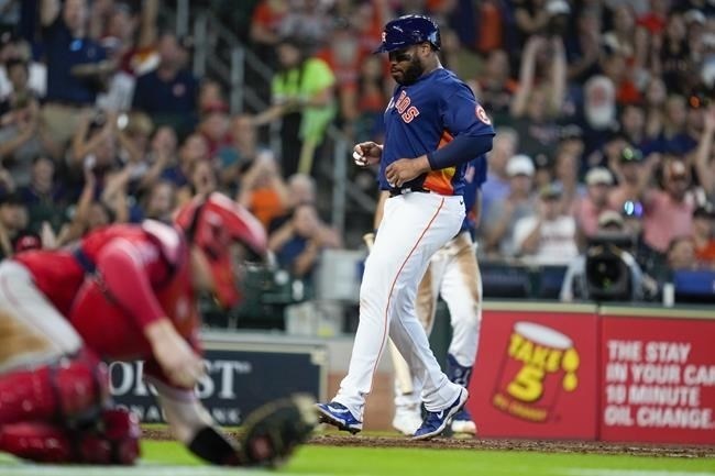 Houston Astros' Jon Singleton, right, scores a run on a wild pitch by Los Angeles Angels relief pitcher Jose Soriano during the sixth inning of a baseball game, Sunday, Aug. 13, 2023, in Houston.