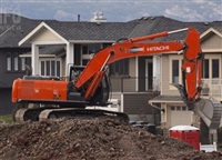 A backhoe digs a basement for a house in Kelowna.