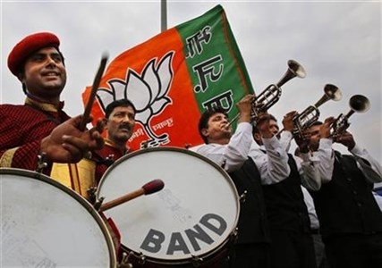 Members of an Indian band perform outside the airport as they wait for the arrival of Bharatiya Janata Party leader and India's next prime minister Narendra Modi in New Delhi, India, Saturday, May 17, 2014.