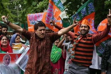 Bharatiya Janata Party (BJP) supporters dance to celebrate the victory of Narendra Modi-led Bharatiya Janata Party in India's general elections in Srinagar, India, Saturday, May 17, 2014.
