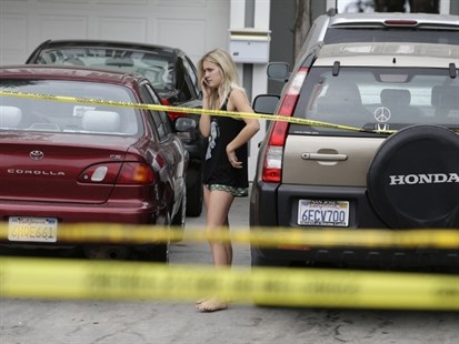 A college student talks on the phone near the scene of a shooting on Saturday, May 24, 2014, in Isla Vista, Calif.