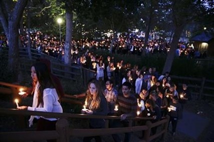 People gather at a park for a candlelight vigil to honor the victims of Friday night's mass shooting on Saturday, May 24, 2014, in Isla Vista, Calif.