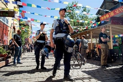 FILE - Police patrol Pusher Street in at Christiania, Copenhagen, Friday, May 25, 2018, after the street reopened after having been closed for three days. The inhabitants of Copenhagen's freewheeling Christiania neighbourhood want dig up the aptly named Pusher Street where cannabis has been sold for decades although the trade is illegal, in the latest attempt to stop the hashish sale which has led to deadly gang turf wars and sometimes violent confrontations with the police.
