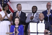 Maryland Gov. Wes Moore holds up an executive order he signed to issue more than 175,000 pardons for marijuana convictions on Monday, June 17, 2024 in Annapolis, Md. Maryland Secretary of State Susan Lee is seated left. Standing left to right are Lt. Gov. Aruna Miller, Maryland Attorney General Anthony Brown, Shiloh Jordan and Jason Ortiz, director of strategic initiatives for Last Prisoner Project.