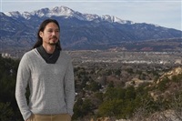 Lane Belone poses with Pikes Peak in the background on an overlook in Palmer Park, Thursday, Dec. 19, 2024, in Colorado Springs, Colo. 