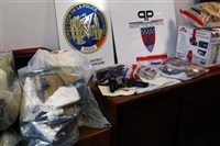 FILE - Packages of cocaine, at left, weapons, and evidence are presented as part of 41 kilograms (90 pounds) of cocaine seized in a plane coming from the Dominican Republic at Orly airport, in Paris, Thursday, Jan. 14, 2016.