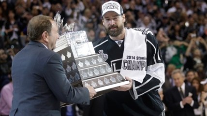 Los Angeles Kings right wing Justin Williams, right, is handed the Conn Smythe Trophy by NHL commissioner Gary Bettman, left.