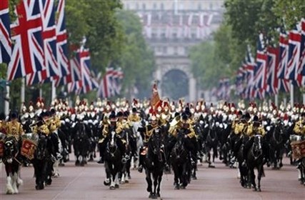 British soldiers ride their horses as the escort Queen Elizabeth II in a horse drawn carriagevas she returns to Buckingham Palace, during the Trooping The Colour parade, in central London, Saturday, June 14, 2014.