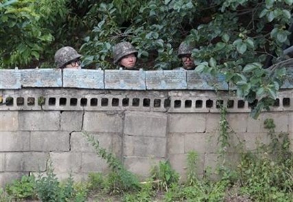 South Korean army soldiers hide behind a wall of a private house during a gunfight with a South Korean conscript soldier.