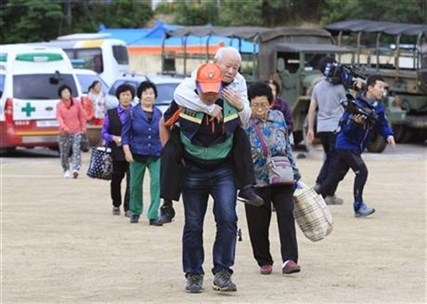 Residents arrive at a shelter to avoid a gunfight between South Korean army soldiers and a South Korean conscript soldier who is on the run.