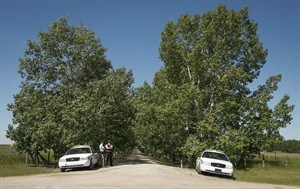 RCMP officers guard an entrance as police continue to search a property northeast of Airdrie, Alta., Wednesday, July 9, 2014. Investigators are looking for clues to the disappearance of a five-year-old boy and his grandparents. 