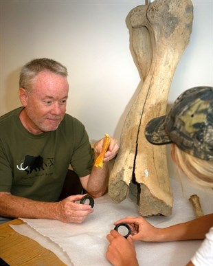 Rob Young, left, and recent grad Lisa Hettrich examine the humerus and compare it to one from a Woolly Mammoth.