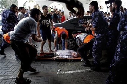 Palestinian medics carry a wounded woman to an emergency room at Shifa hospital in Gaza City, Sunday, July 20, 2014.