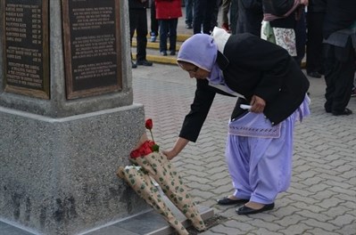 A family member lays a rose on the memorial on April 6, 2013 in commemoration of nine loved ones murdered in 1996.