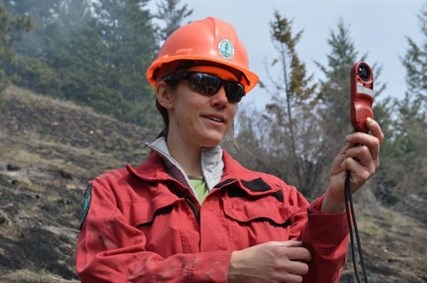 Katherine Ladyman of the Okanagan Shuswap Natural Resource District uses an instrument to check wind speed, relative humidity and temperature before the burn begins. 