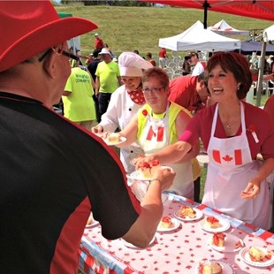 Christy Clark serving cake at Westside Daze Canada Day celebration in West Kelowna.