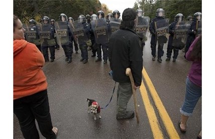 Protesters face a line of police officers in Rexton, N.B.