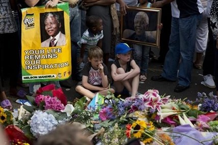 Children look at tributes outside the home of former president Nelson Mandela in Johannesburg, South Africa, Saturday, Dec. 7, 2013.