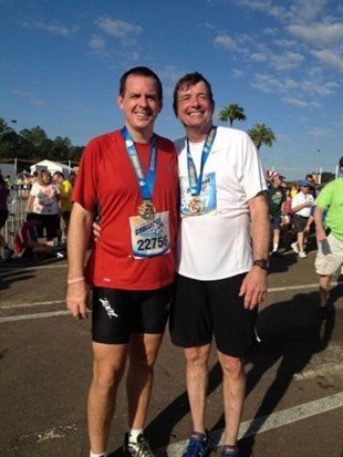 In this Jan. 12, 2013 photo provided by the family, Doug Olson, right, and his son, Jon, stand together after running a half-marathon in Orlando, Fla. As of December 2013, Doug Olson, 67, a scientist for a medical device maker, shows no sign of cancer since gene therapy in September 2010 for chronic lymphocytic leukemia he had had since 1996. 
