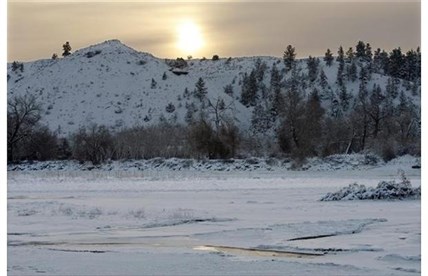 The sun rises over the hills south of the Yellowstone River in Billings, Mont. as the temperatures hover around 20 degrees below zero on Saturday, Dec. 7, 2013.