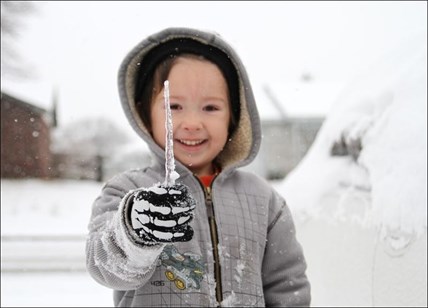 Jared Shepard, 5, plays in the snow in his front yard after several inches of snow and ice blanketed the area Friday, Dec. 7, 2013 in Van Buren, Ark.