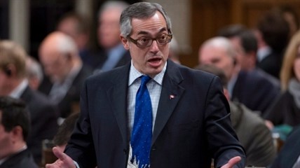 Wearing a tie showing the children's book character the Grinch, Treasury Board President Tony Clement responds to a question during Question Period in the House of Commons in Ottawa, Tuesday, Dec. 3, 2013. 