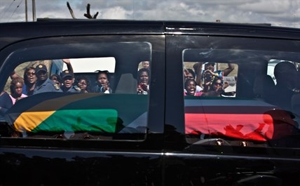 South African mourners wave and cheer as the hearse transporting the body of Former President Nelson Mandela passes through the town of Mthatha on its way to Qunu, South Africa, Saturday, Dec. 14, 2013.