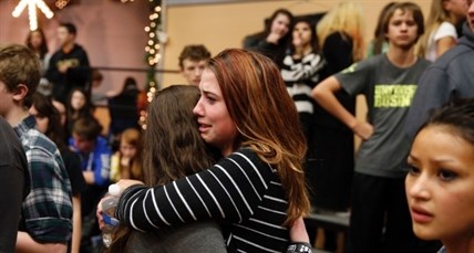 Freshman Allie Zadrow, center right, hugs classmate Liz Reinhardt at a church after a shooting at nearby Arapahoe High School in Centennial, Colo., on Friday, Dec. 13, 2013.