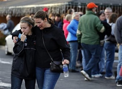 A parent picks up her daughter at a church where students from nearby Arapahoe High School were evacuated to after a shooting on the Centennial, Colo., campus Friday, Dec. 13, 2013. Arapahoe County Sheriff Grayson Robinson said the shooter shot two others at the school, before apparently killing himself.