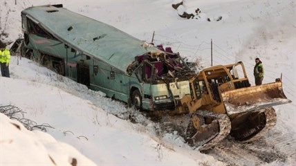 A piece of heavy equipment strains to move a bus which plummeted 200 feet down an embankment in rural Eastern Oregon the day before, on Monday, Dec. 31, 2012.
