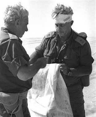 In this Oct. 10, 1973 file photo, Maj. Gen. Ariel Sharon, right, views a map together with Maj. Gen. Haim Bar-Lev in the Sinai desert, during the 1973 Middle East War.