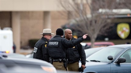 Police talk in a parking lot outside a Sears store after a shooting at The Mall in Columbia in Columbia, Md. on Saturday, Jan. 25, 2014.

