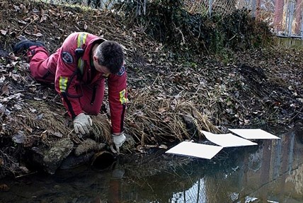 Investigators check a culvert pipe as a potential source for the spill.