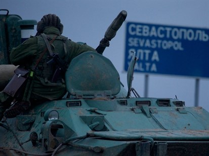 A soldier rests atop a Russian armoured personnel carrier near the town of Bakhchisarai, Ukraine on Friday, Feb. 28, 2014. The border between Russia and Ukraine is all but open, labour flows freely, goods are exchanged without customs and three million Ukrainians work in Russia now.