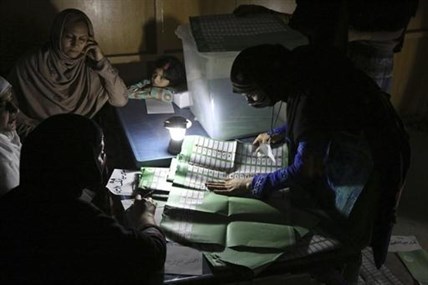 Afghan election workers count ballots by the light of a lantern at a polling station in Jalalabad, east of Kabul, Afghanistan, Saturday, April 5, 2014.