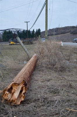 One end of this wooden pole rests on the left hand side of Old Kamloops Rd while the other end rests on the right hand side amongst a jumble of wood and other objects. 