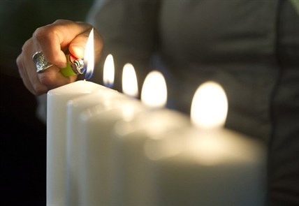 A candle is lit at a memorial event held at the University of Calgary on Thursday, April 17, 2014