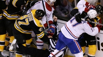 An official tumbles to the ice as Boston Bruins players fight with Montreal Canadiens players during the second period of Game 2 in the second-round of the Stanley Cup hockey playoff series in Boston, Saturday, May 3, 2014.