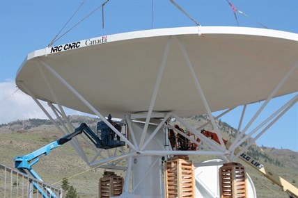 Engineers secure the dish to the tower.