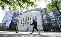 A woman walks past the Bank of Canada headquarters, Wednesday, June 1, 2022 in Ottawa. 